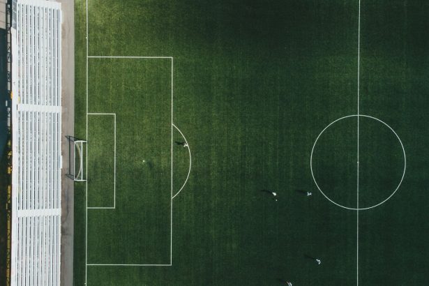 Vista aérea de um campo de futebol com jogadores em ação durante uma partida.