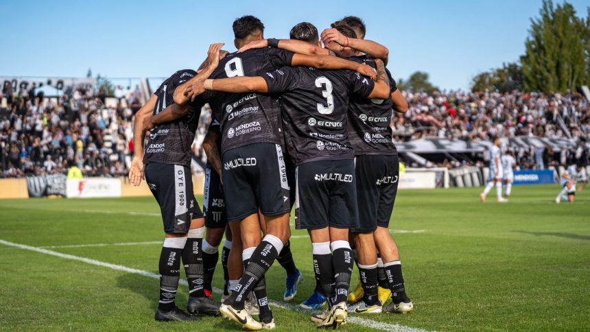 Jogadoras de futebol comemoram um gol durante uma partida em um estádio lotado